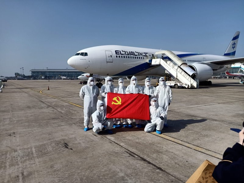 צוות אל על עם דגל המפלגה הקומוניסתית בסין. צילום: אל על
