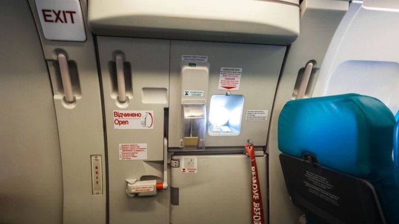 34015251 - closeup shot of emergency exit door in airplane