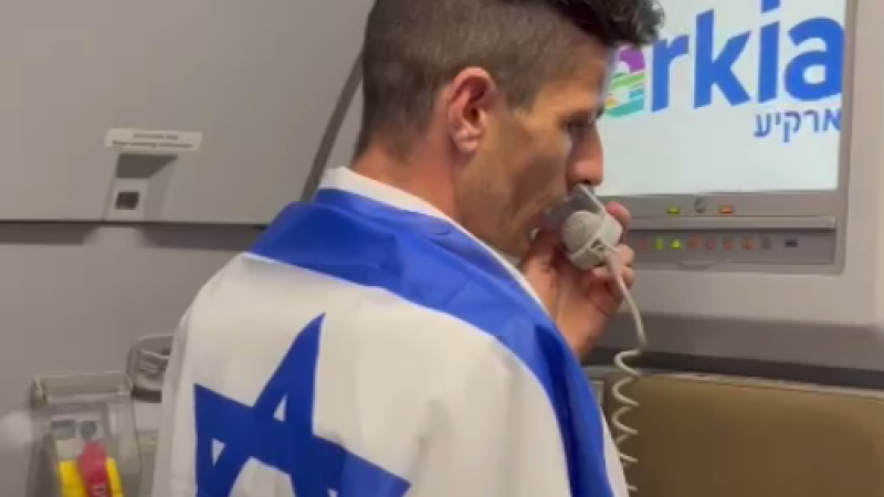 מנהל השירות בטיסת ארקיע עם דגל ישראל (צילום: ארקיע)